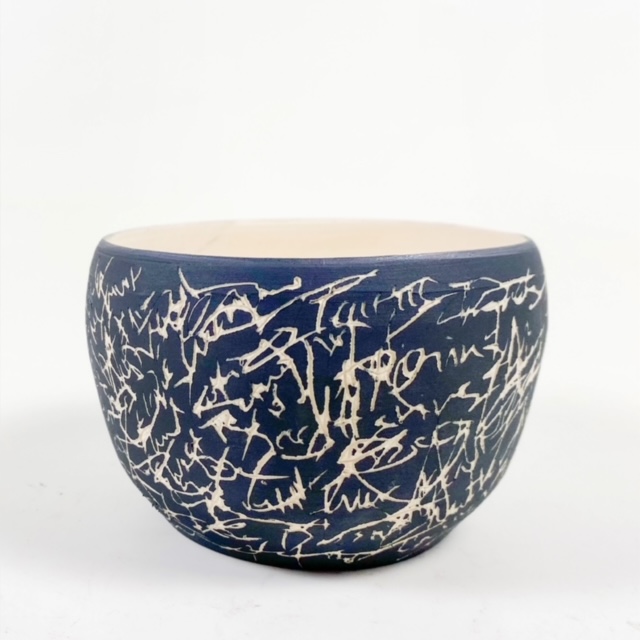 Dark ceramic bowl with white line drawing