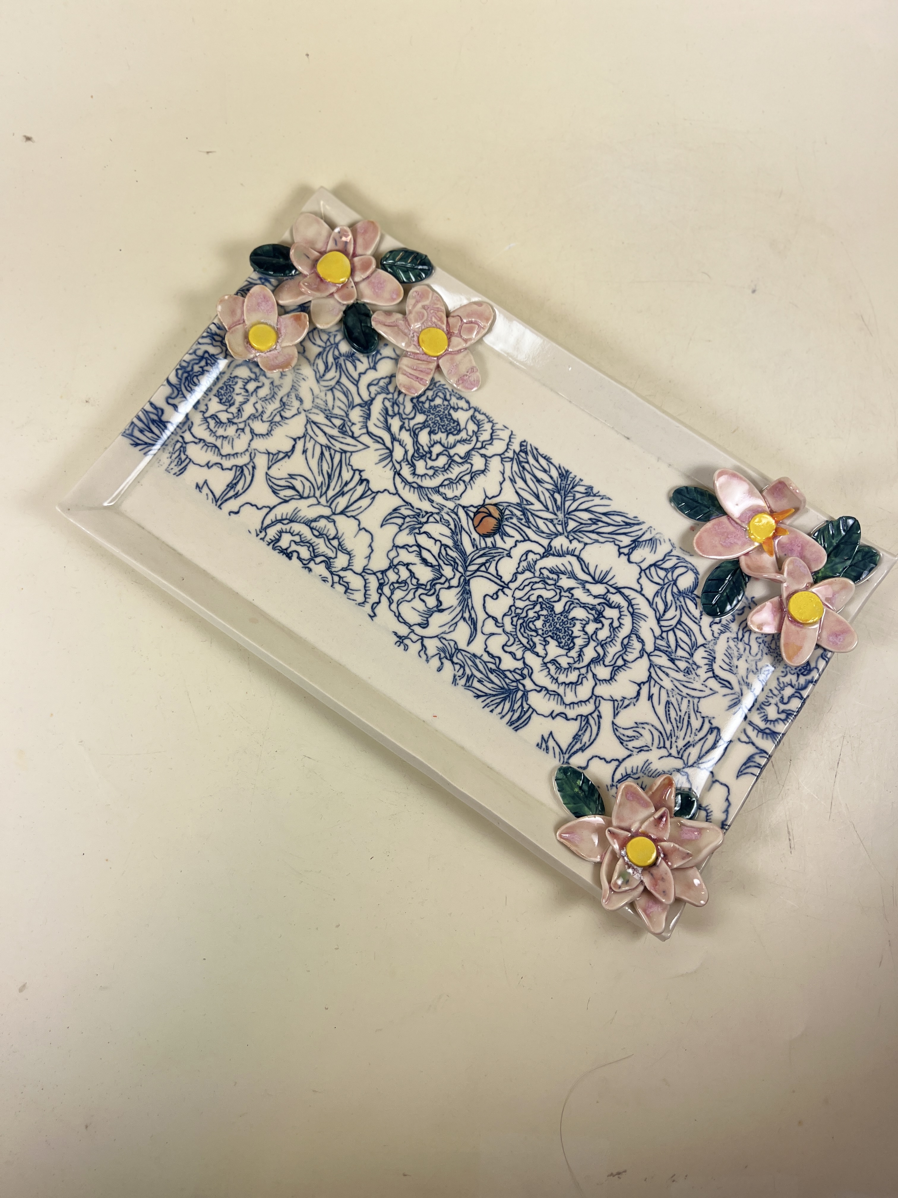Rectangular tray with blue floral print and pink sculptural flowers