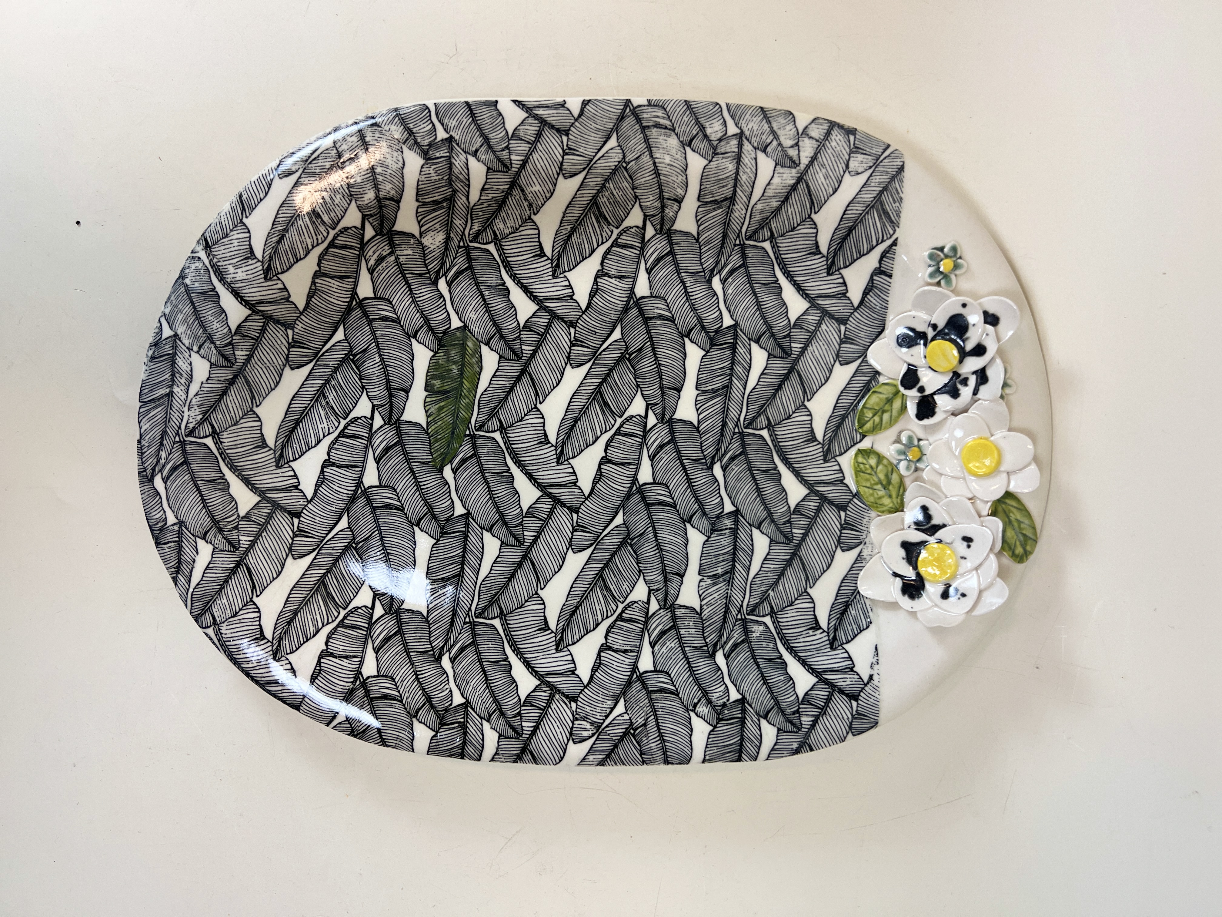 Large oval platter with banana leaf transfer print and sculptural flowers