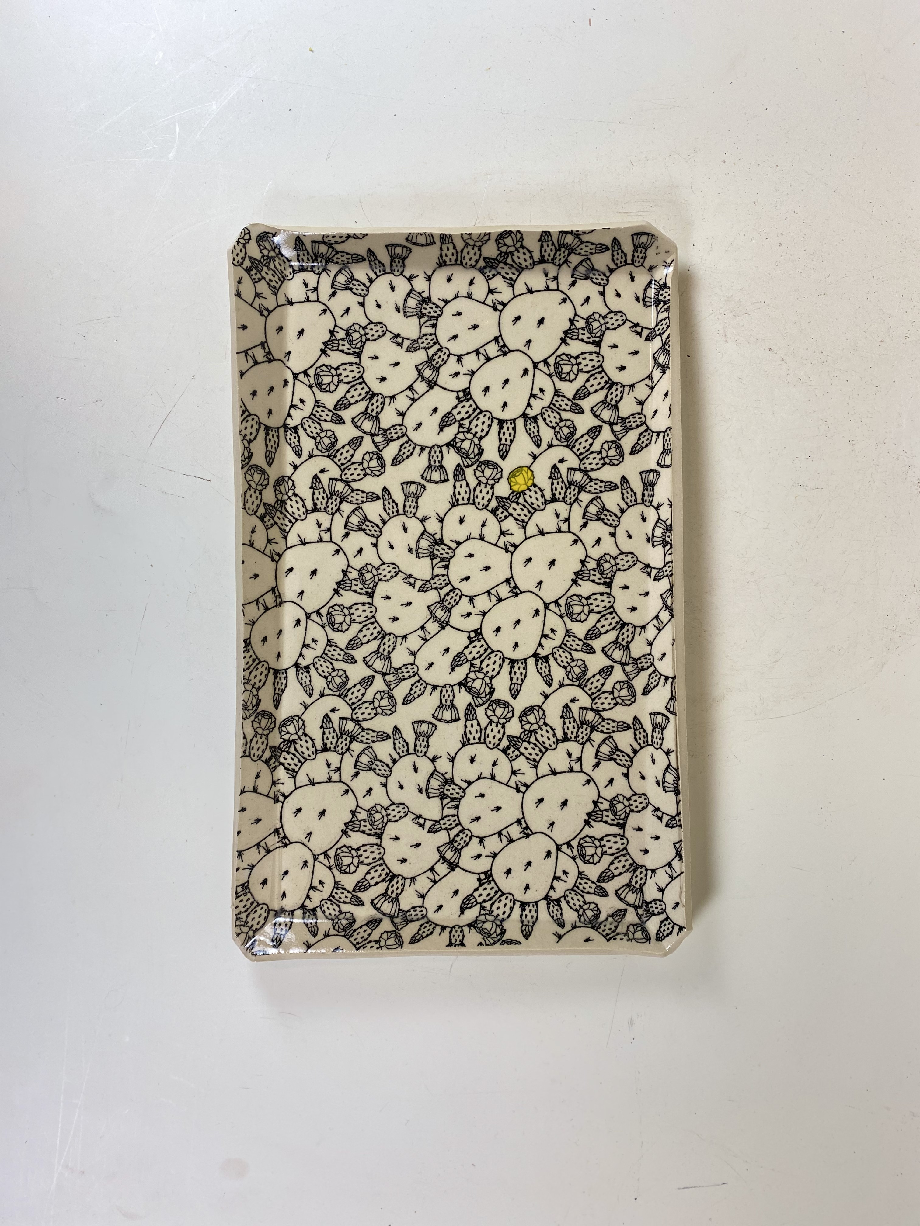 Rectangular ceramic tray with dense cactus transfer print and a single yellow gem detail