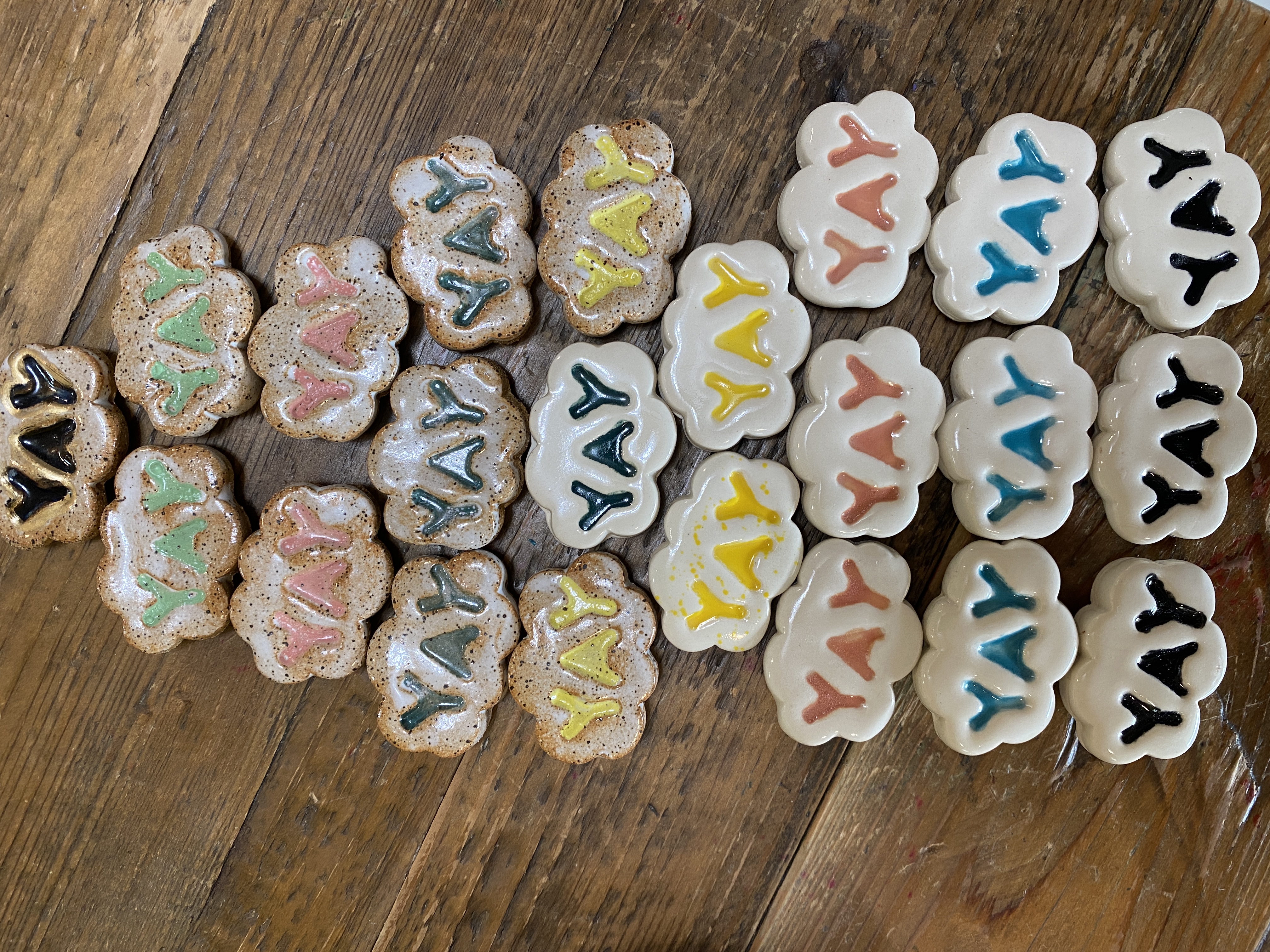 Collection of cloud-shaped ceramic magnets with YAY lettering in many colorways